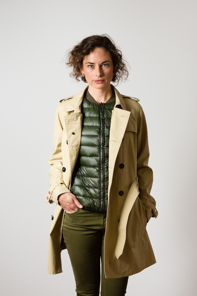 Katharina wearing the British Millerain Trench Coat over a forrest green goose down liner vest